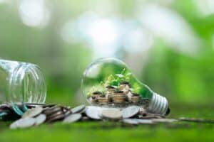 plantas crescendo em uma lâmpada, dando a impressão de ideia sustentável e consciente. Uma muda está crescendo em uma moeda caída no chão. conceito de economia inteligente para comércio